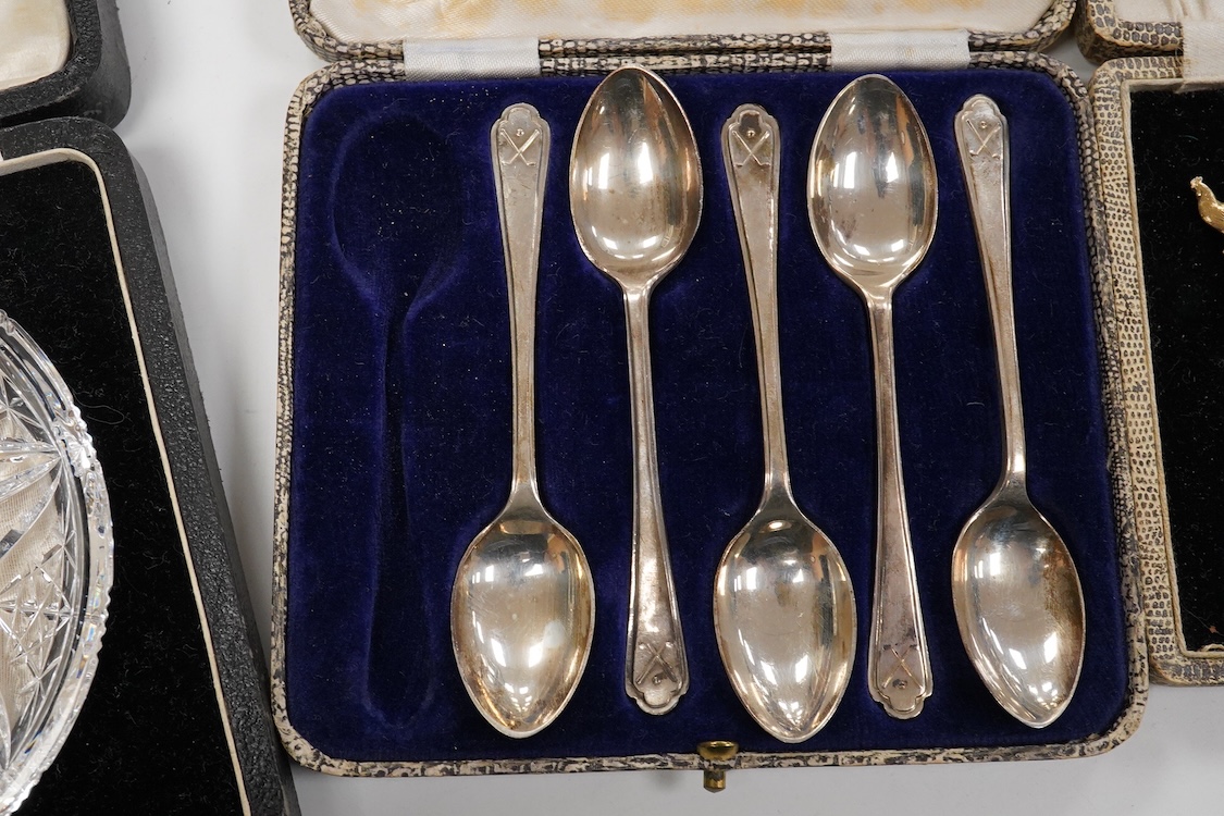 A collection of assorted silver to include five napkin rings including two pairs, a cased pair of glass butter dishes with silver butter knives, five golf related teaspoons, a cased set of six sterling cocktail sticks wi